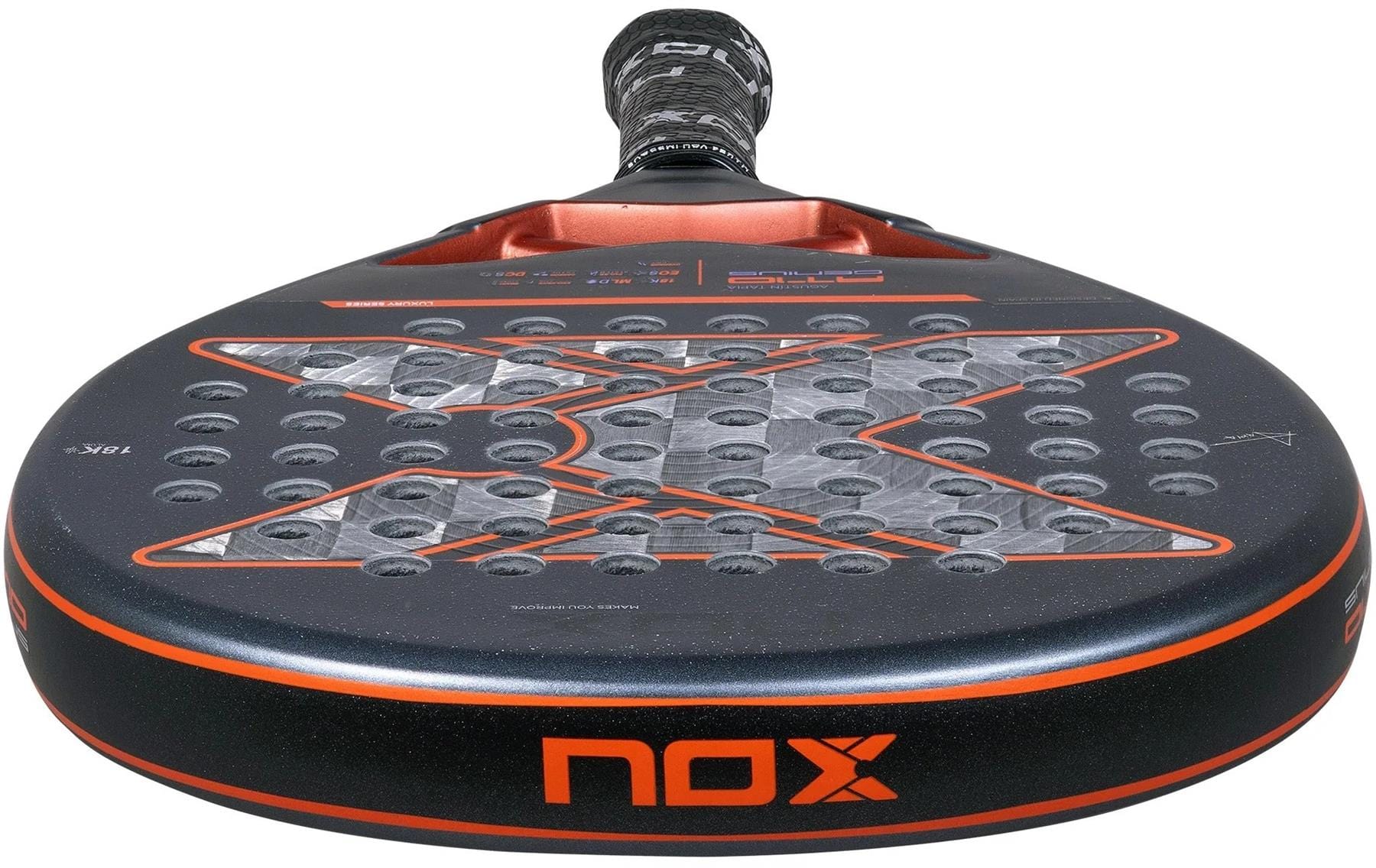 Close-up of the NOX AT10 Luxury Genius 18K Alum By Agustin Tapia 2025 Padel Racket in black and orange, featuring an 18K Alum textured surface with circular holes, a bold "X" design, and a comfortable black and grey grip.