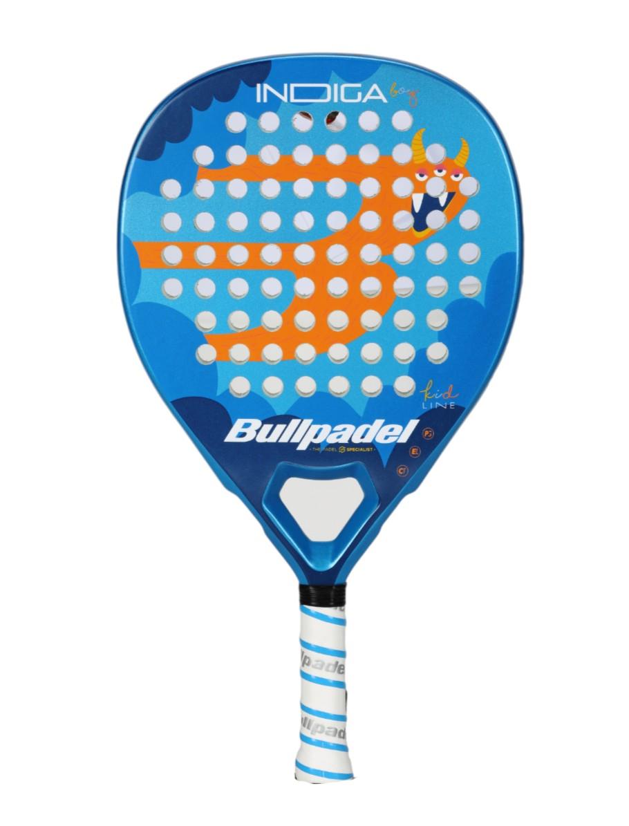 The Bullpadel Indiga Junior 25 Boys Padel Racket boasts a lively blue design with Grip Zone technology, white perforations, "Bullpadel" branding on the shaft, and an orange cartoon character with horns for a dynamic look.