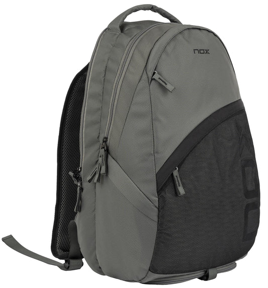The NOX Street Series Padel Backpack - Grey features two main zippered compartments, a black mesh front pocket, and ergonomic padded straps. Stands upright to display its sleek side and front—ideal for sports adventures. Brand: NOX.