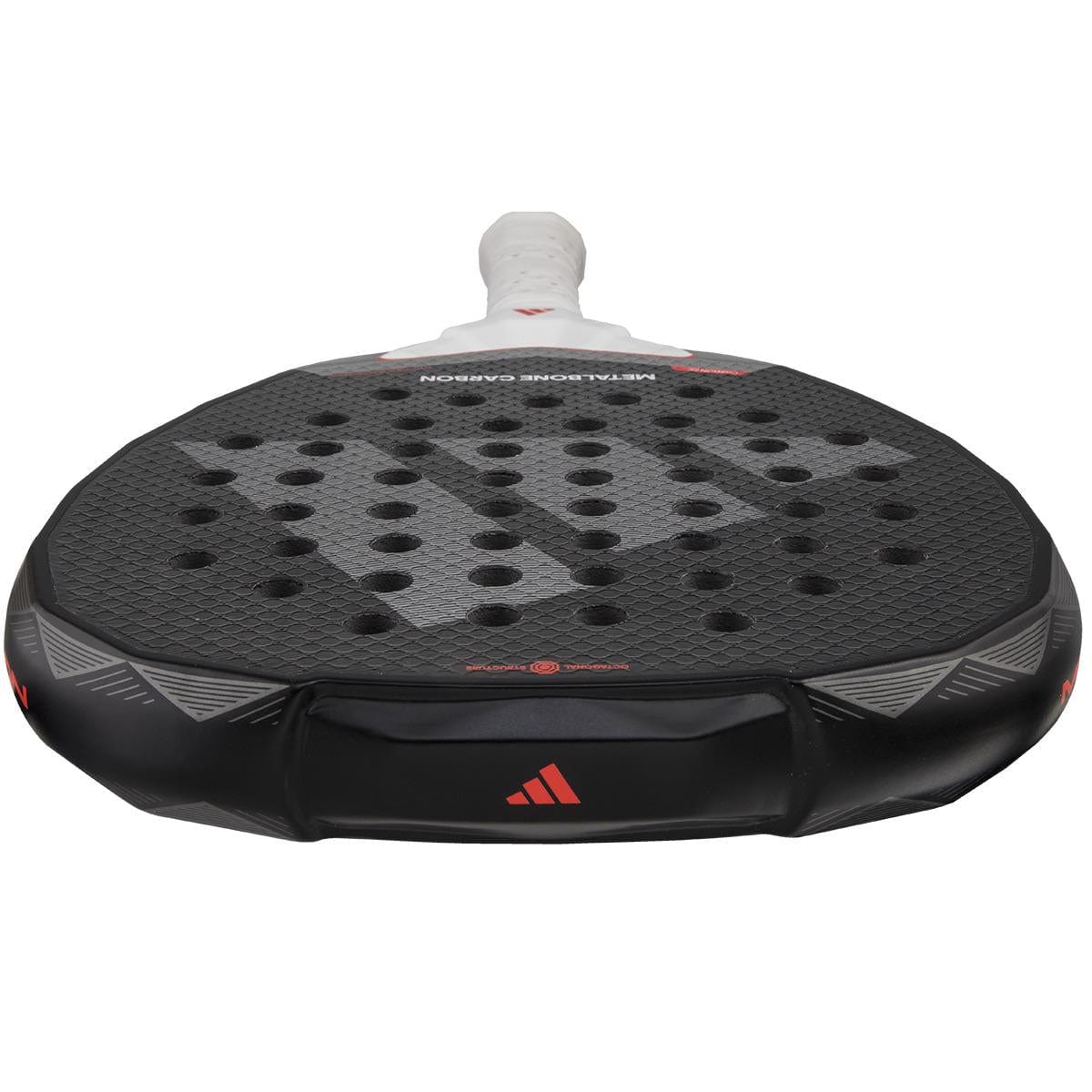 Close-up of the adidas Metalbone Carbon 3.4 Padel Racket in black/white, showcasing its textured surface with holes. Designed for advanced players, it has a white grip handle and features red accents and a logo on the edge.