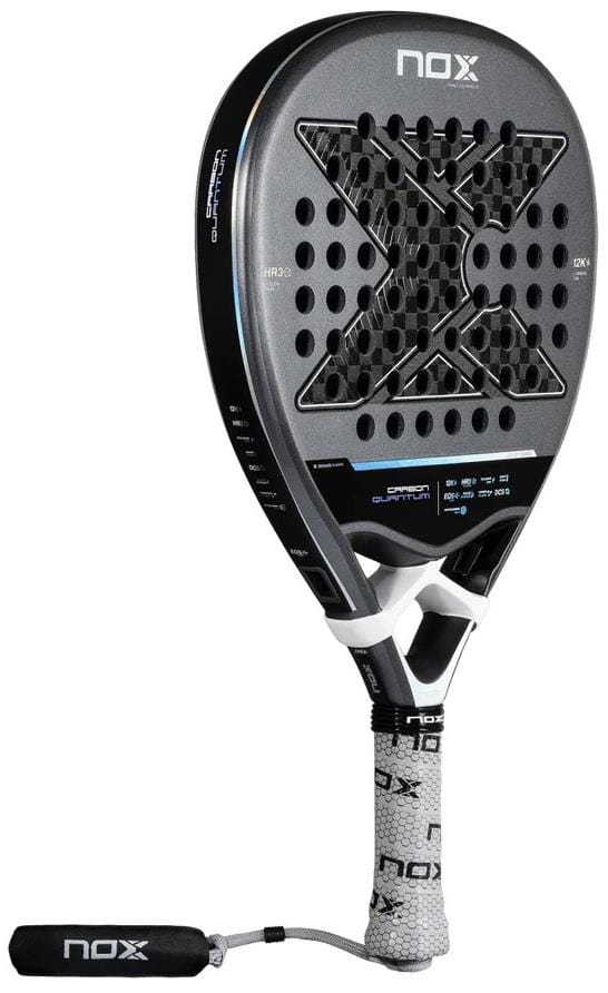 The NOX Luxury Quantum 12K Carbon 2025 Padel Racket in black/grey features a large "X" center design, textured surface with EXCLUSIVE SPIN tech, 12K carbon fibre build, circular holes, white grip, and branded wrist strap.