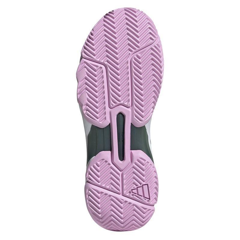 The image presents the sole of a sneaker, likely part of the ADIDAS CourtJam Control 3 Women's All Court Shoes series in Bronze Strata, Legend Ink, and Bliss Lilac. It showcases a zigzag pattern to enhance traction. The design is completed with grooves and a logo near the heel area, while much of the shoe remains hidden. Its construction using recycled materials underscores its eco-friendly appeal.