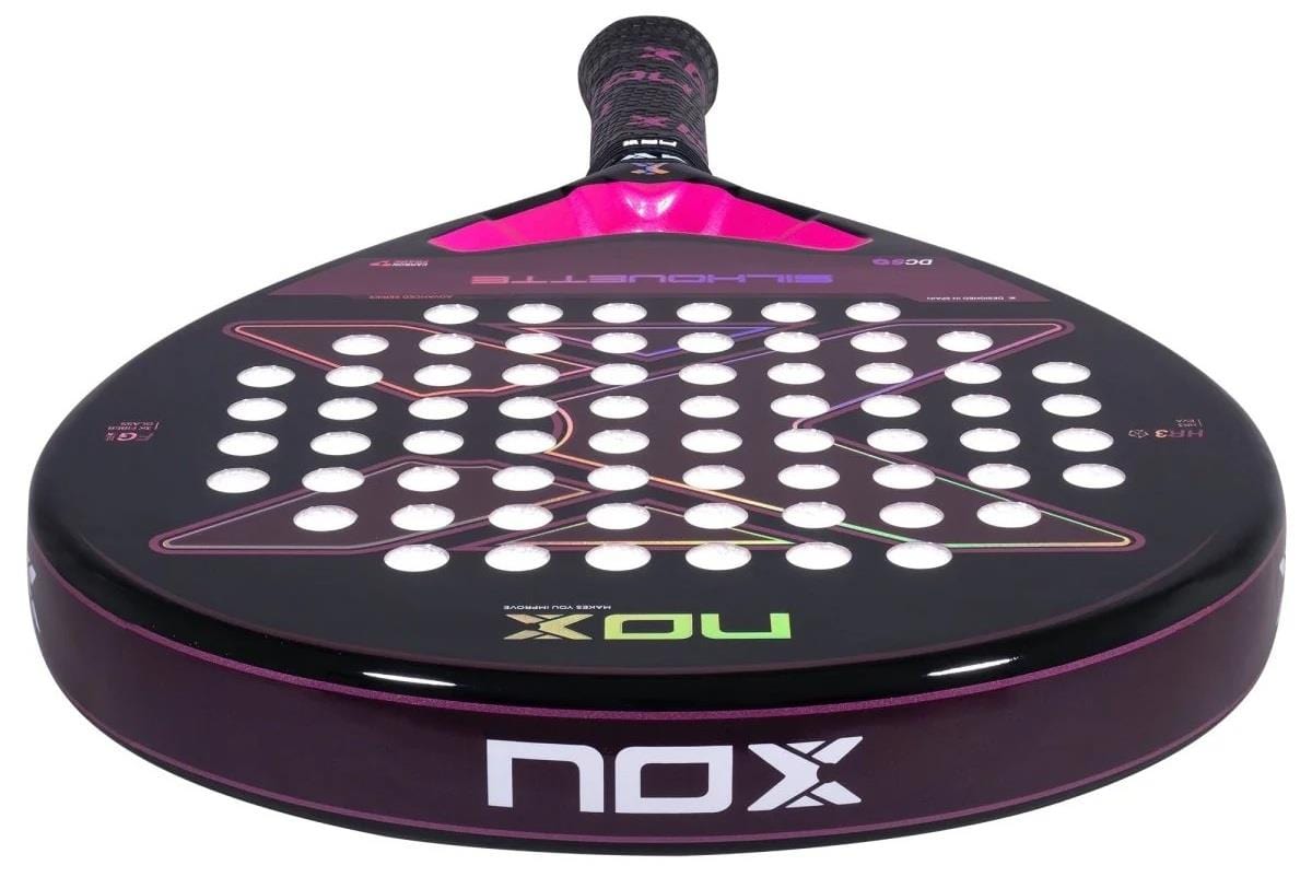 A close-up of the NOX X-One Silhouette Advance Series Padel Racket in black and pink, featuring multiple face holes, an HR3 core for enhanced performance, and the NOX logo on the lower edge.