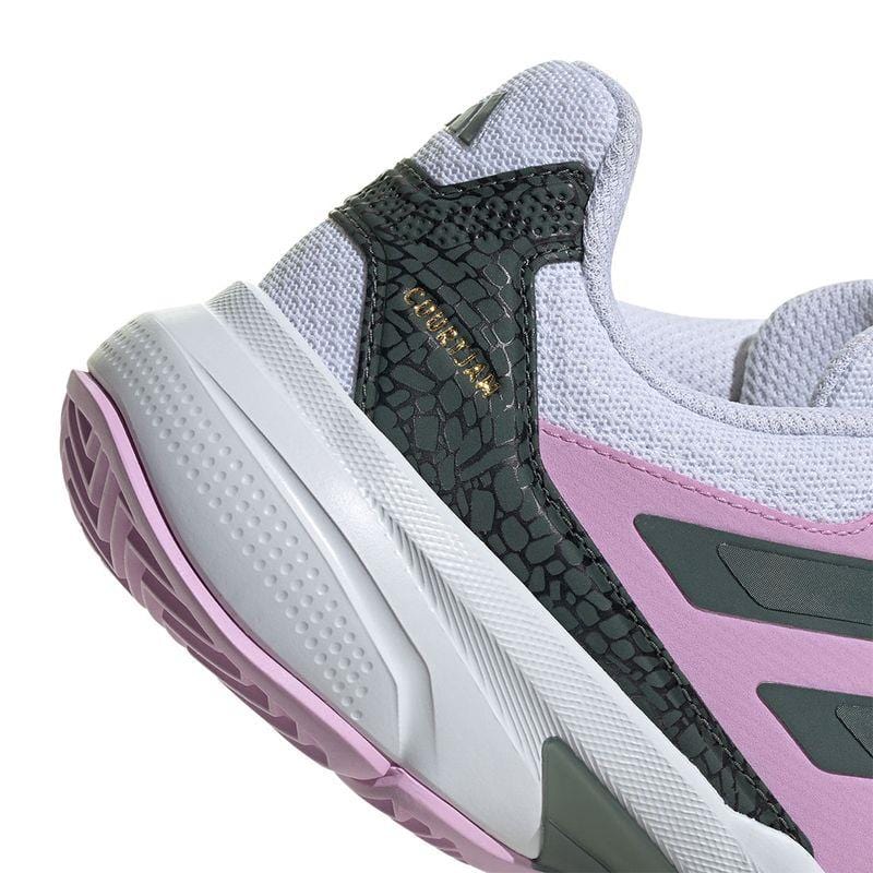 Close-up of the ADIDAS CourtJam Control 3 Women's All-Court Shoes from adidas, showcasing a textured heel in bronze strata and legend ink, alongside bliss lilac side panels and dark gray accents. This modern design features a visible tread on the sole and a textured upper, incorporating recycled materials for an eco-friendly touch.