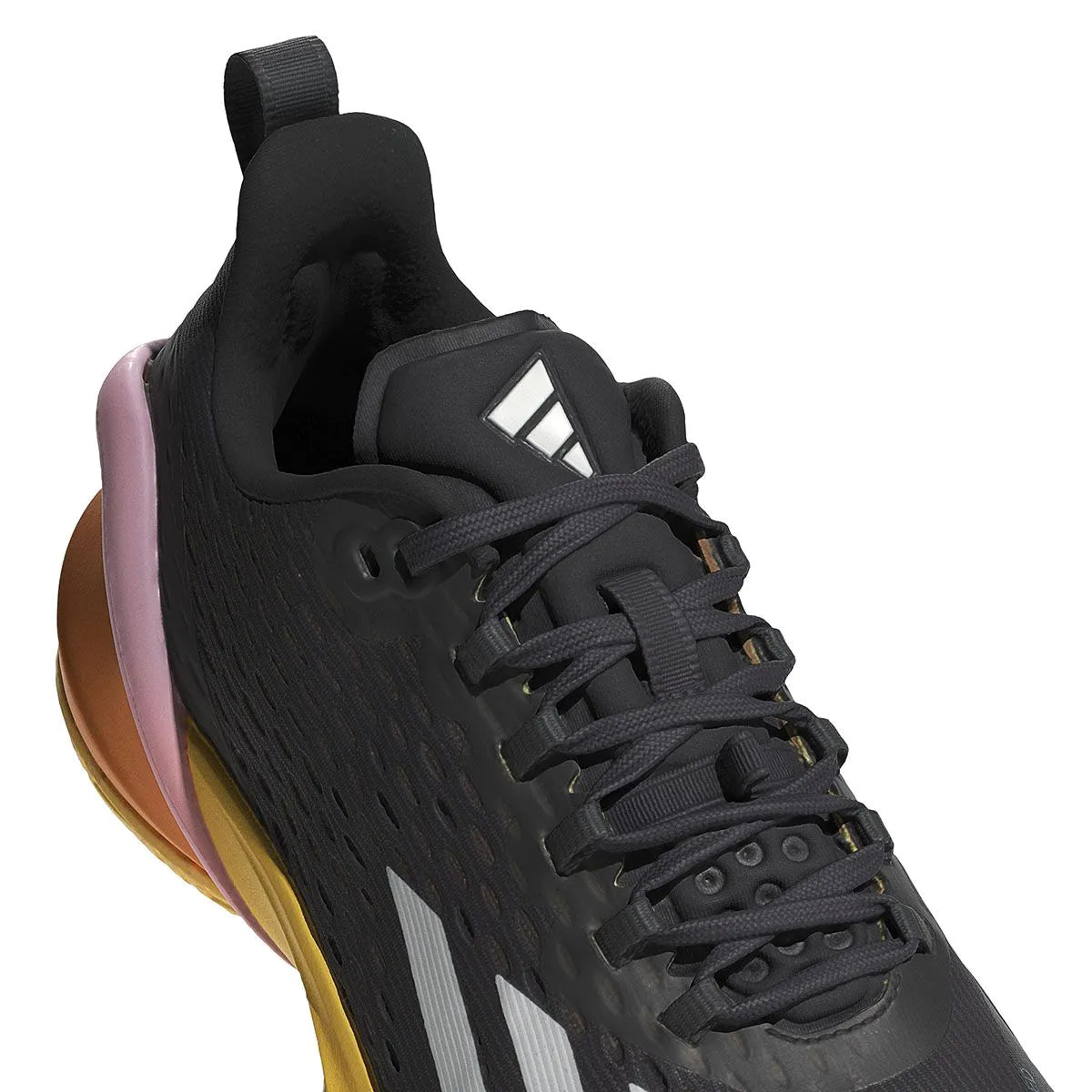 A close-up of the ADIDAS Adizero Cybersonic Men's All Court Shoes in Aurora Black, Zero Metallic, and Spark displays a textured upper with a visible adidas logo on the tongue. These athletic shoes feature dark laces paired with a pink and gold sole, while Energy Rods boost performance. A pattern of small holes ensures enhanced breathability.