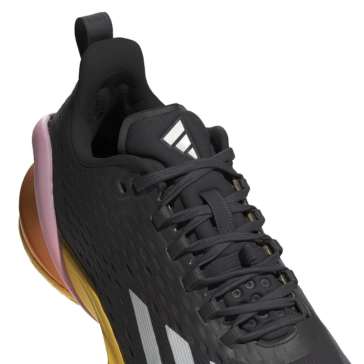 A close-up of the ADIDAS Adizero Cybersonic Men's All Court Shoes in Aurora Black, Zero Metallic, and Spark displays a textured upper with a visible adidas logo on the tongue. These athletic shoes feature dark laces paired with a pink and gold sole, while Energy Rods boost performance. A pattern of small holes ensures enhanced breathability.