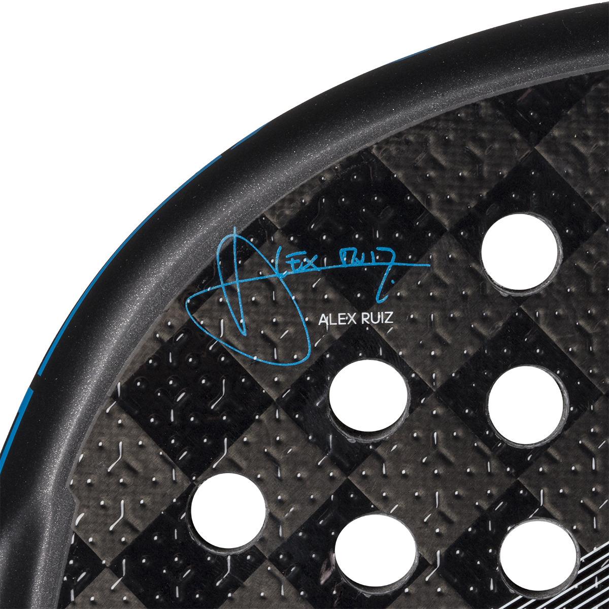 Close-up of an adidas Adipower Multiweight CTRL 3.4 padel racket, highlighting its carbon fiber-patterned surface with circular holes and a blue "Álex Ruiz" signature near its sleek black edge.