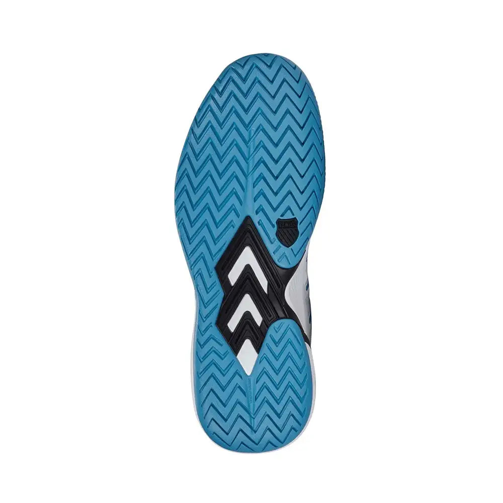 The image displays the sole of K-Swiss Ultra Court Men's Padel Shoes in White/Black/Blue Moon, featuring a blue zigzag pattern with black accents and a small black shield logo at the center. This unique tread design, along with its cushioning system, boosts grip and traction.