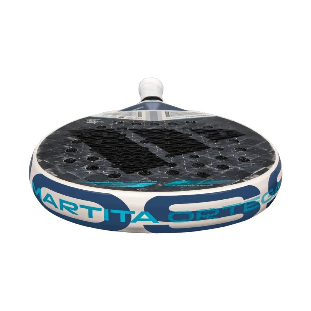 A close-up of the adidas Cross It Light 3.4 Padel Racket - Chalk White showcases its perforated surface, sleek blue accents, and "Martita Ortega" detail, emphasizing its Dynamic Air Flow technology for superior performance.