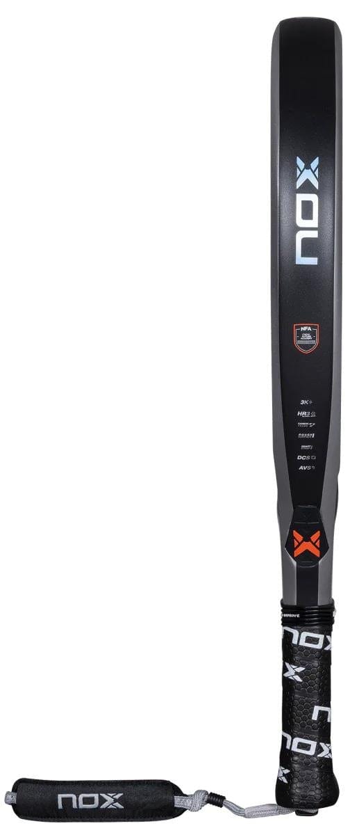 The NOX NFA Nextgen Pro Hybrid 3K Padel Racket in silver/black stands upright, displaying its side profile. Made with 3K Carbon and HR3 Black Eva, it features a black grip tape with the NOX logo and an attached wrist strap.