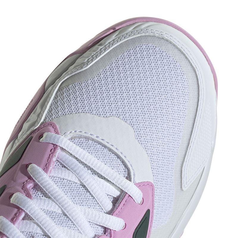 The ADIDAS CourtJam Control 3 Women's All Court Shoes in Bronze Strata, Legend Ink, and Bliss Lilac feature a white mesh upper with pink and white overlays. They are enhanced with a Bounce midsole for comfort, have white laces, black detailing on the sides, and are crafted using recycled materials.