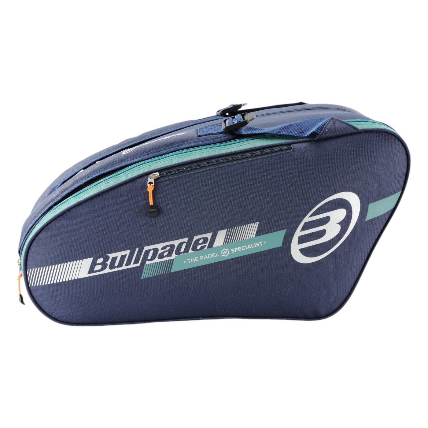 The Bullpadel Tour 25 Padel Racket Bag - Navy features a spacious rounded main compartment, a side pocket with an orange zipper, and "Bullpadel" branding. Ideal for padel enthusiasts, it includes a padded compartment to protect your racket.