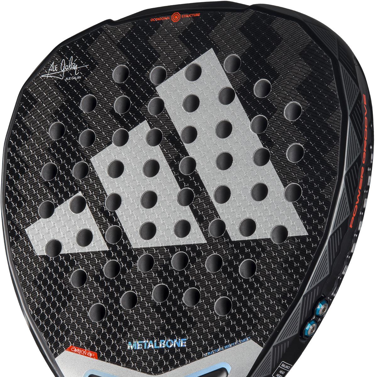 The ADIDAS Metalbone 3.4 Padel Racket in Black/White is ideal for advanced players, featuring a textured surface with circular holes, a prominent white logo at the center, and "METALBONE" and various signatures accentuating its sleek design.