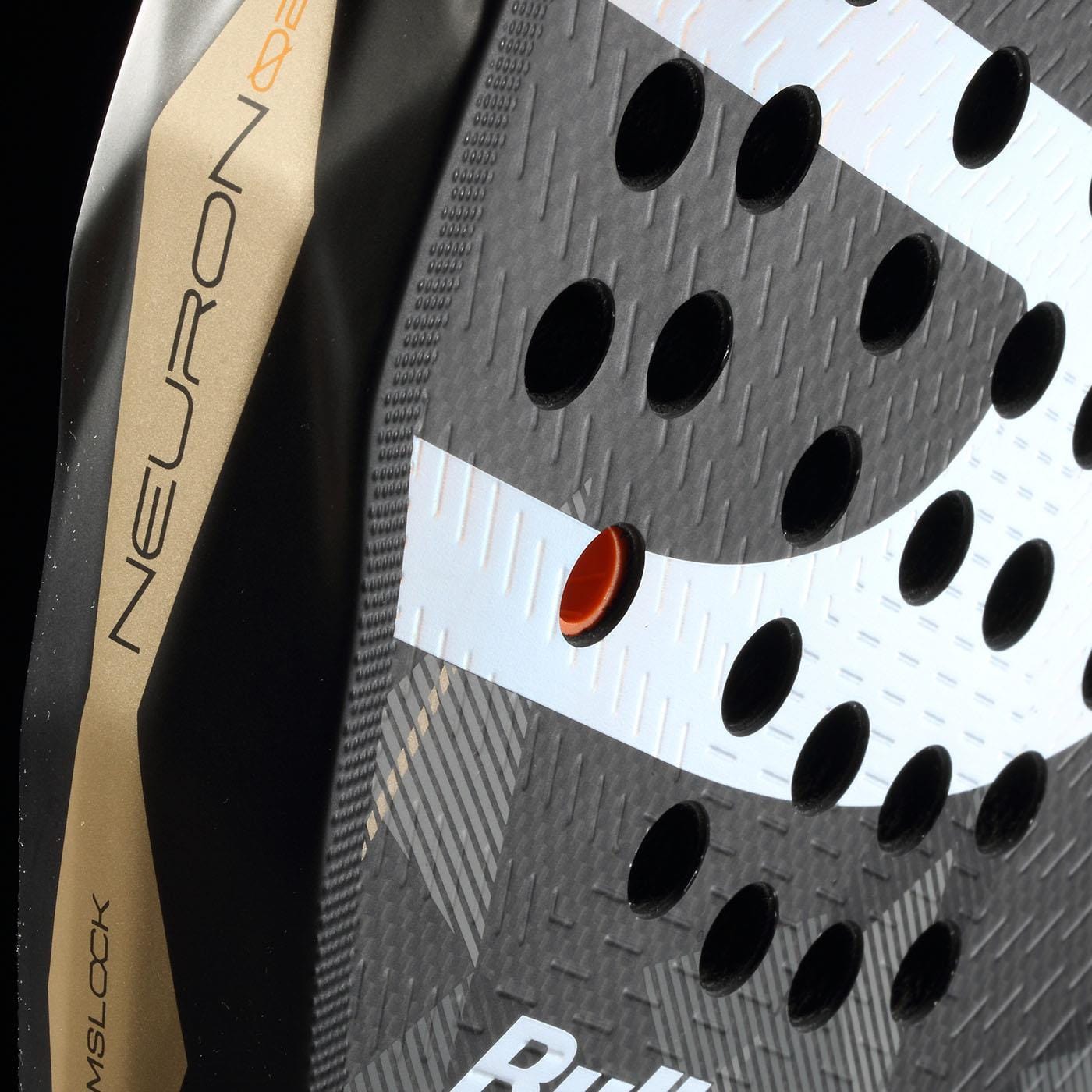 Close-up of the Bullpadel Neuron 02 2026 Padel Racket in Black/Gold showing "NEURON" lettering, circular holes, and a central orange grommet. Bold texture and Bullpadel branding make it a pro-favorite design.