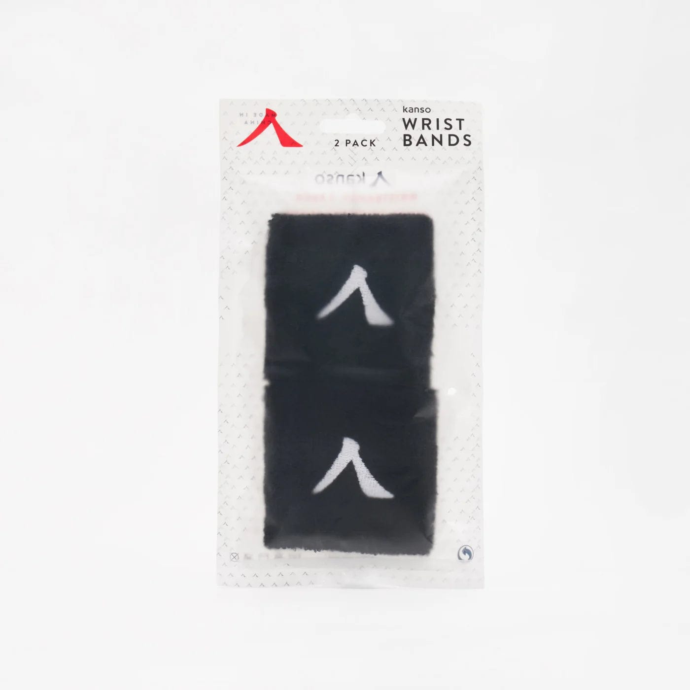 The Kanso 7cm Wristband 2 Pack offers stylish black wristbands with a white symbol, made from absorbent fabric for durability and comfort. The set comes in transparent packaging with a light gray patterned background that highlights the wristbands beautifully.