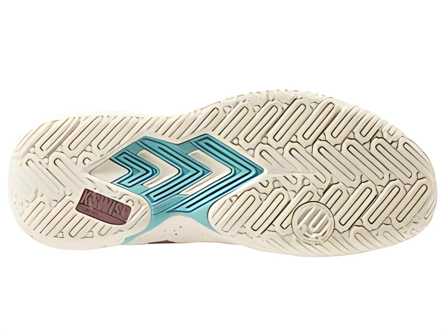 The image shows the sole of the K-Swiss Tura Team Women's Padel Shoes, featuring a beige herringbone pattern for grip with teal and pink accents. Two chevron-like designs and a circular logo are present on one side.