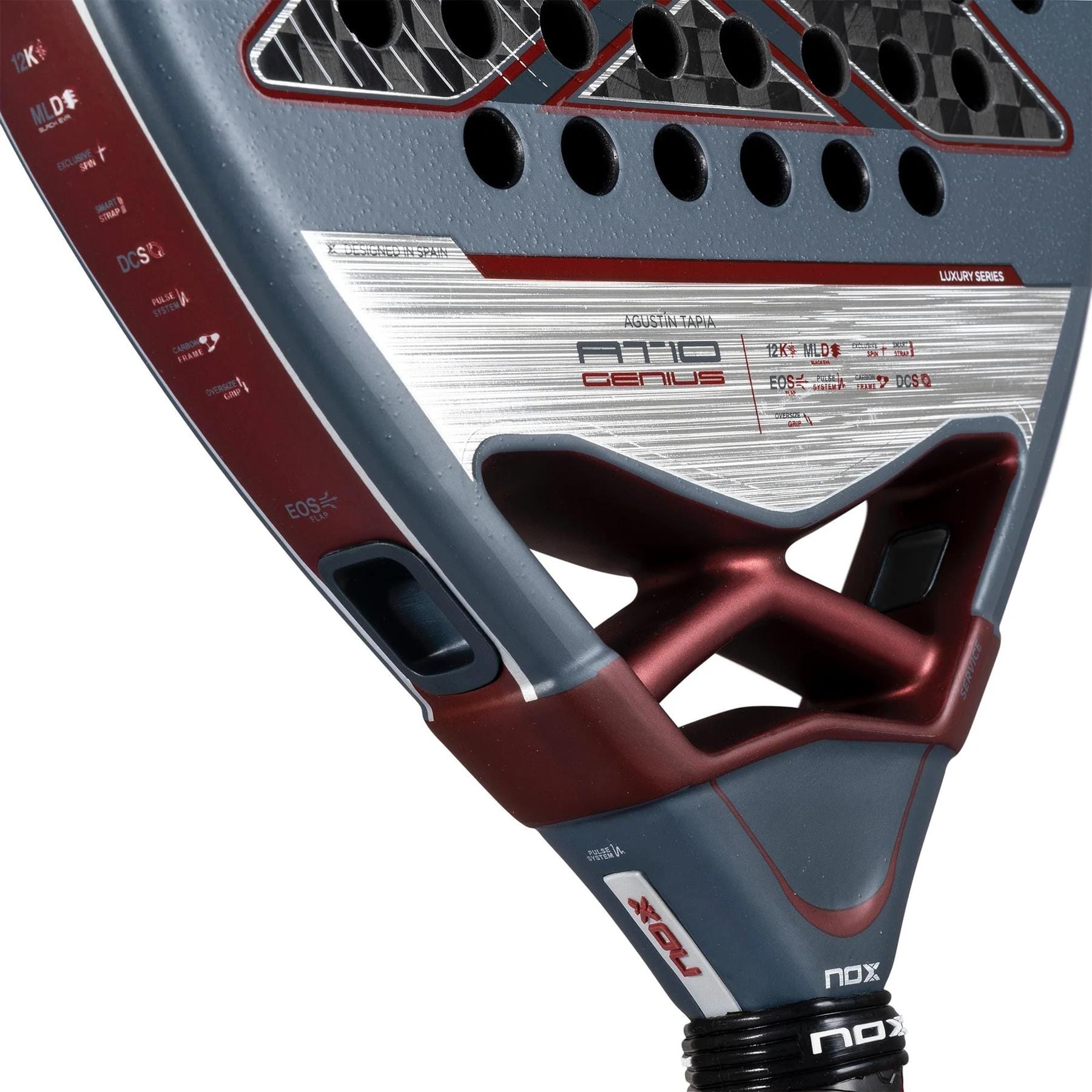Close-up of the NOX AT10 Luxury Genius 12K By Agustin Tapia 2025 padel racket, showcasing detailed textures, 12K carbon fibre, NOX branding, red/gray/silver accents, visible holes, technical specs, and angular design.