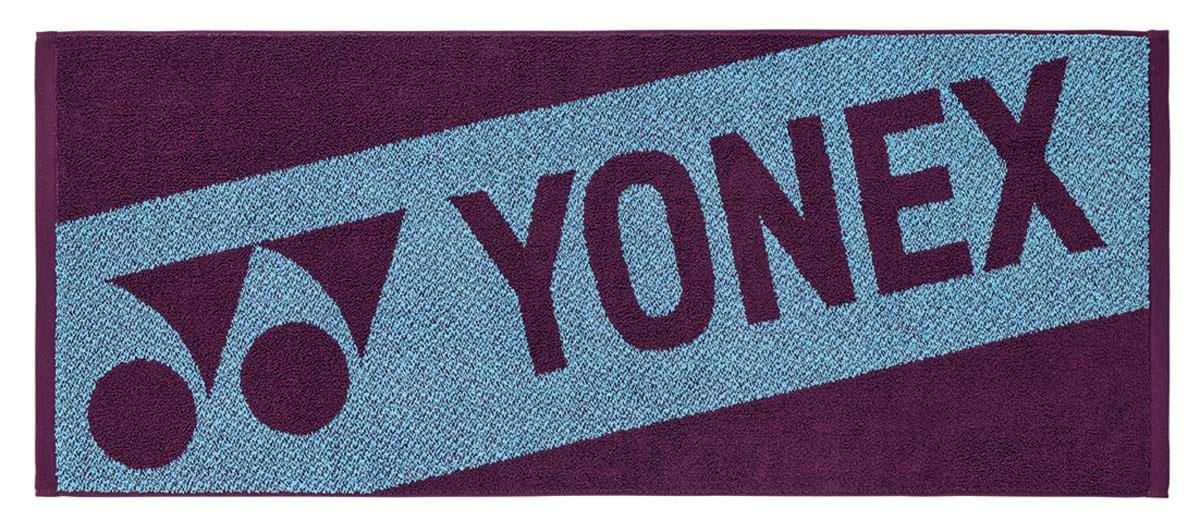 The Yonex AC1113EX Padel Sports Towel - Bordeaux is a rectangular cotton towel with the Yonex logo and name in bold letters on a contrasting two-tone blue and dark purple background, creating an eye-catching design.