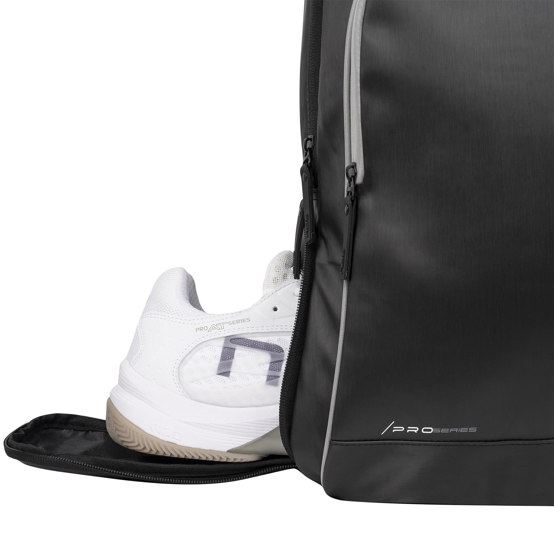 A white athletic shoe is partially tucked into a side compartment of the sleek black NOX Pro Series Padel Backpack, featuring gray zippers, "PRO SERIES" branding on the bottom corner, and ample storage for all your essentials.