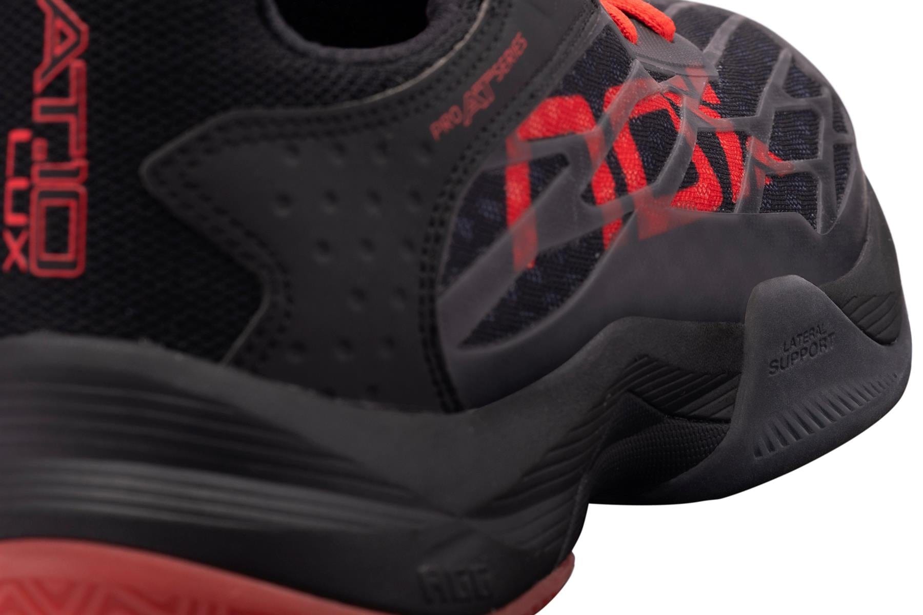 Close-up of the NOX AT10 Lux Men's Padel Shoes in black/red by NOX, inspired by Agustin Tapia, featuring textured patterns and technology labels: "ProAdaptex", "RATIO FLUX", and "Lateral Support" on the side and heel.
