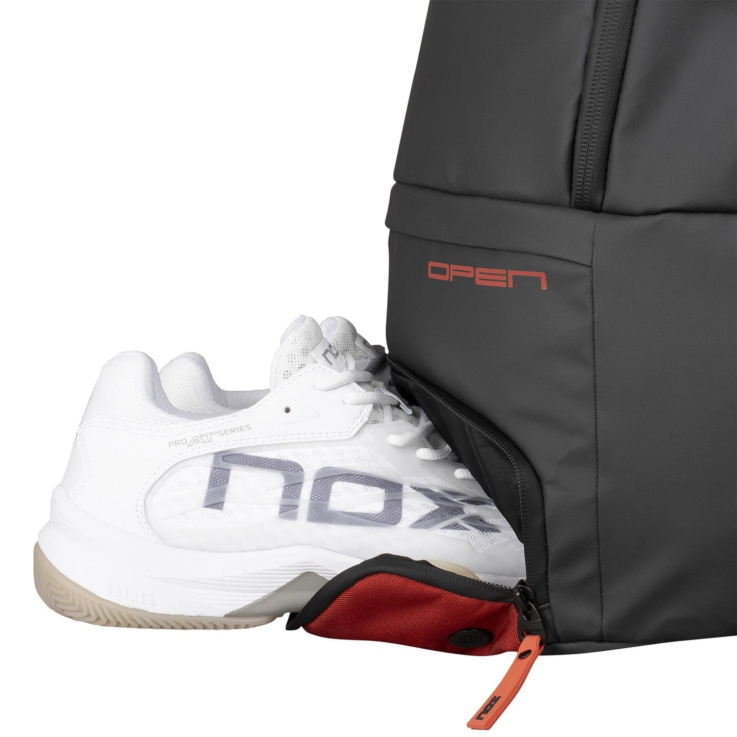 A white sports shoe with "nox" on its side and a beige sole is partly pulled from the NOX Luxury Open Series Padel Backpack - Black / Red, crafted from technical materials and detailed with "OPEN" in bold red letters.