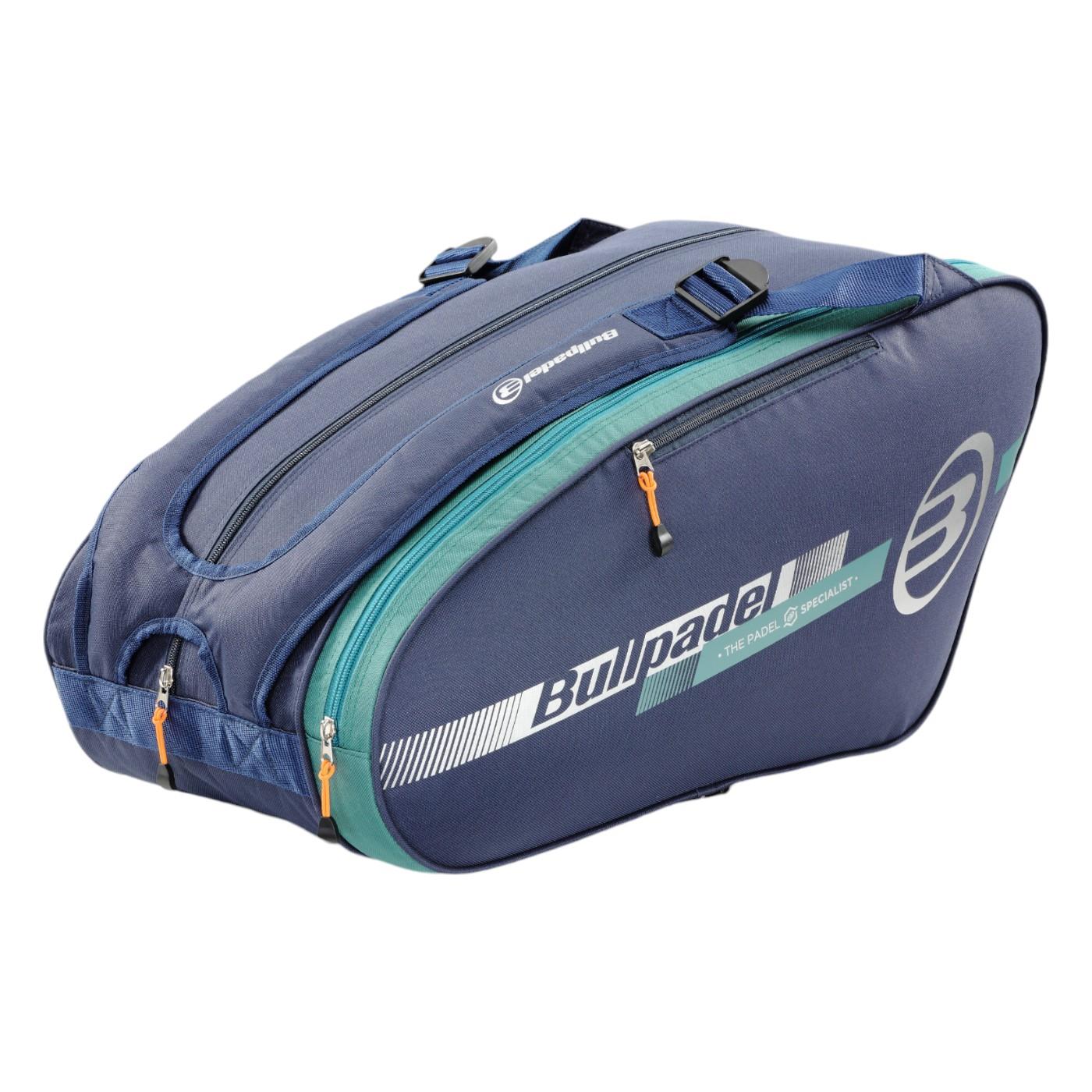 The Bullpadel Tour 25 Padel Racket Bag in navy features three compartments, eye-catching orange zipper pulls, and white branding. It includes a padded section for rackets, ensuring enhanced protection while traveling.
