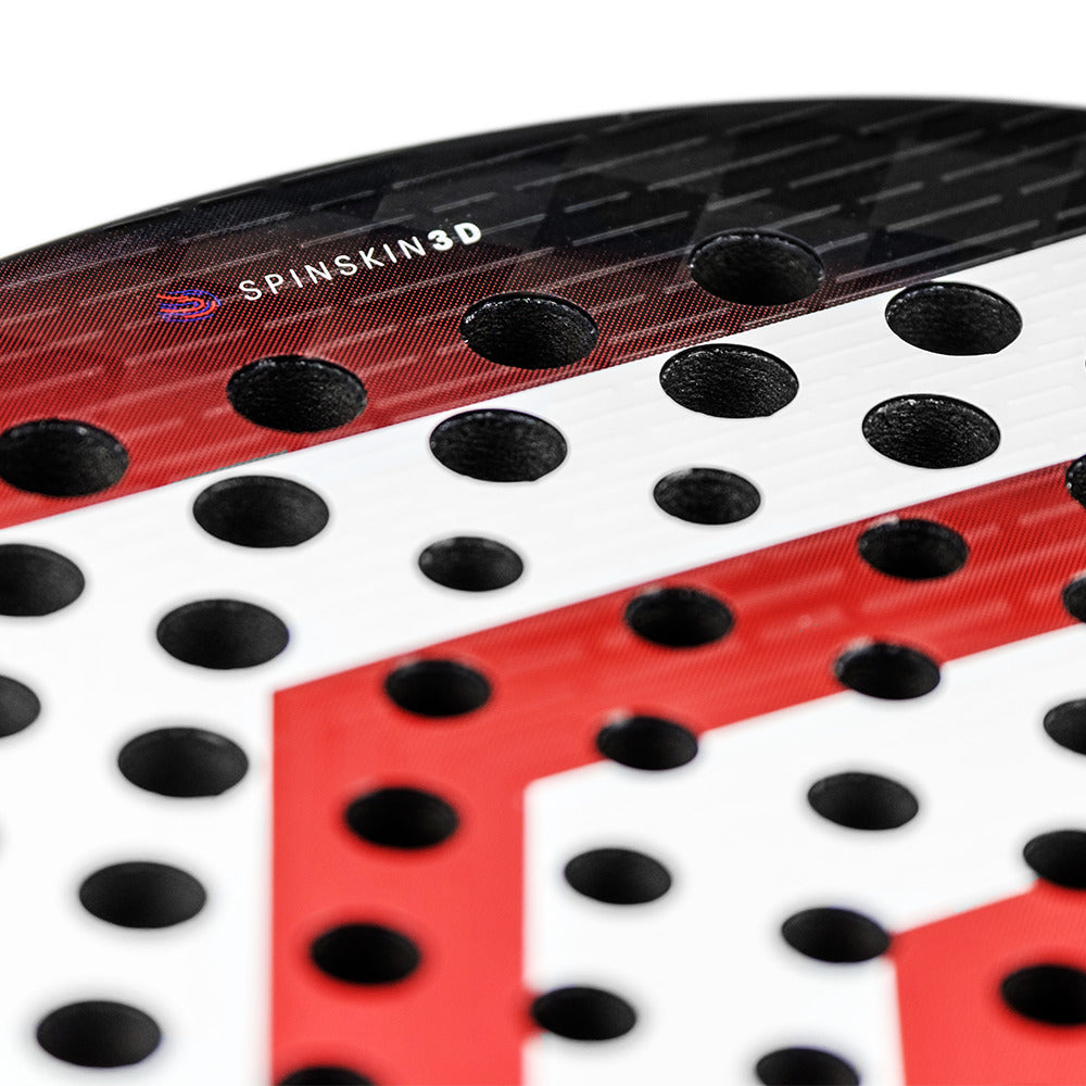 Close-up of a Tecnifibre Curva Speed Padel Racket - Red, showcasing a surface with black round holes, red and white geometric patterns, and "SPINSKIN 3D" printed on the upper section.