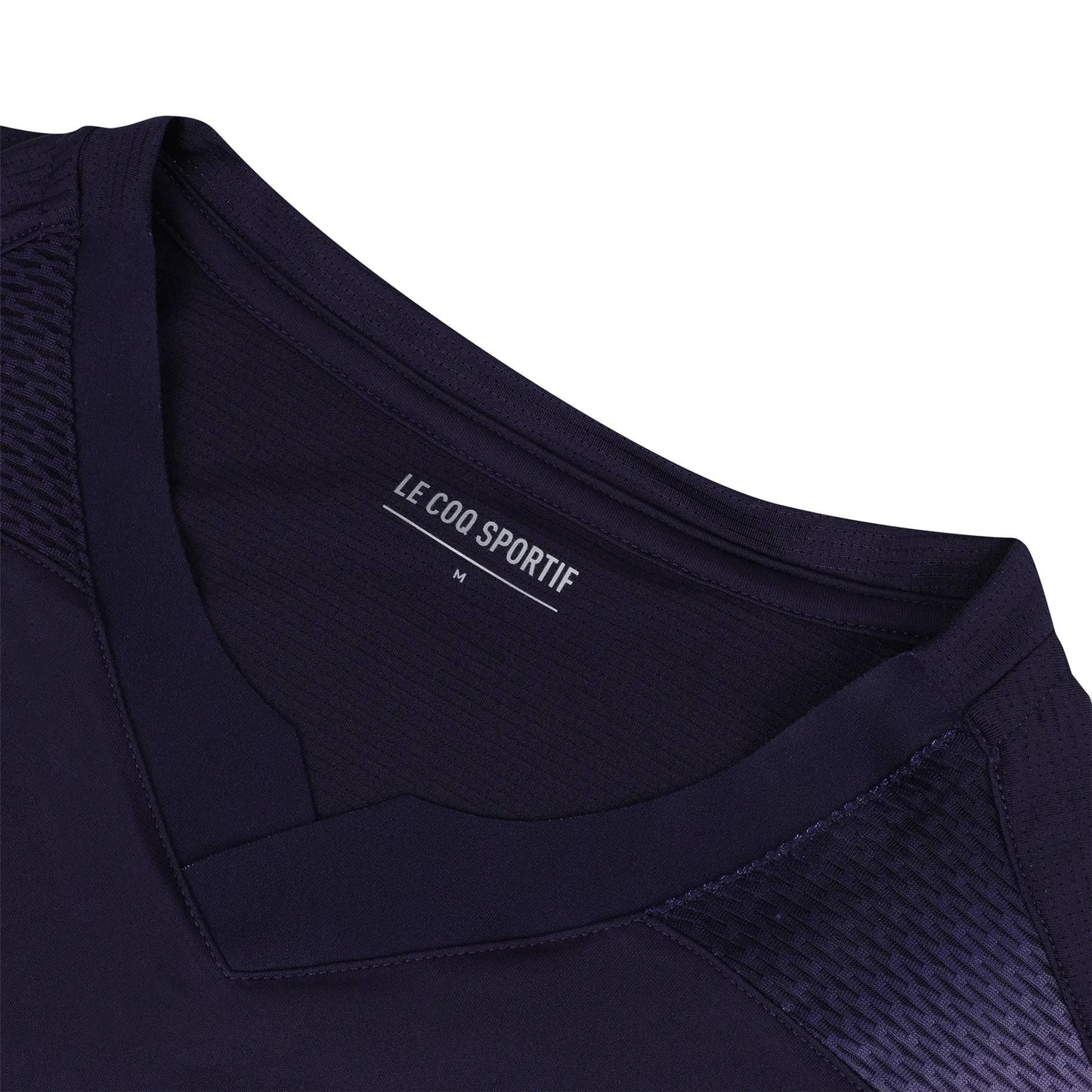 Close-up of a deep purple V-neck padel t-shirt featuring a textured shoulder pattern, showcasing the "Le Coq Sportif" label and size "M" inside the collar. Designed for movement and breathability, this Le Coq Sportif Pro Men's Padel T-Shirt is perfect for your active lifestyle.