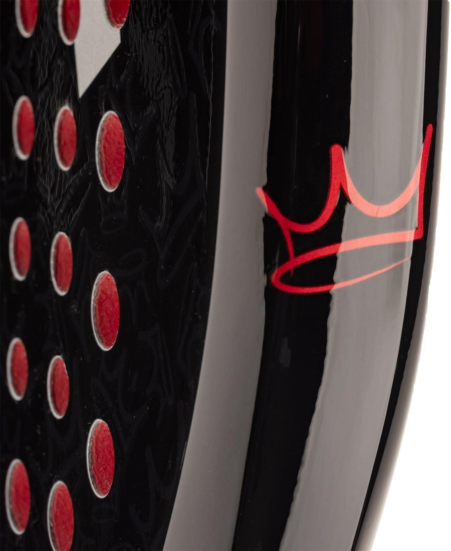 Close-up of the HEAD Coello Team 2025 Padel Racket - Black, showing red circular indents and a stylized red crown. Its glossy surface highlights advanced Power Foam construction by HEAD.