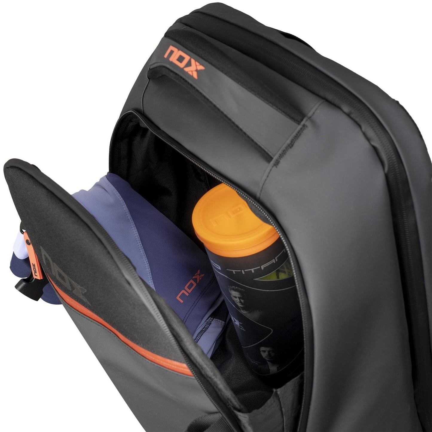 A close-up of the NOX Luxury Open Series Padel Backpack - Black / Red by NOX shows a blue garment, orange water bottle, and an item with a NOX logo in the front zip pocket, all crafted from technical materials.