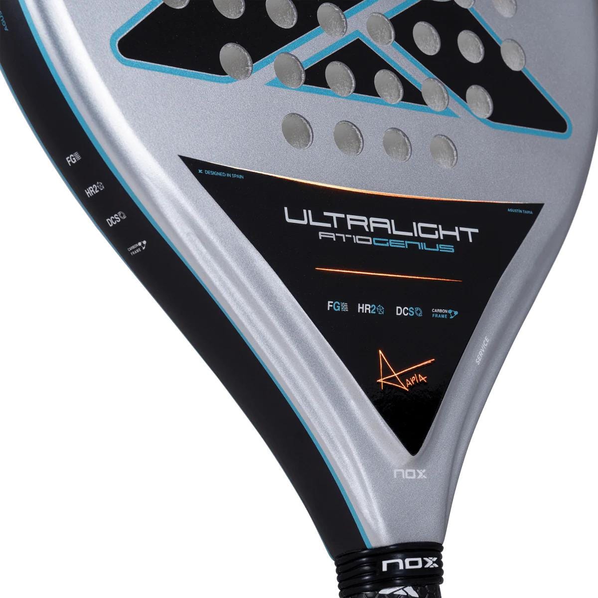 Close-up of the NOX AT10 Genius Ultralight By Augustin Tapia 2025 padel racket in silver and black, showing NOX branding, signature, textured face with circular holes, and an HR2 core for superior performance.
