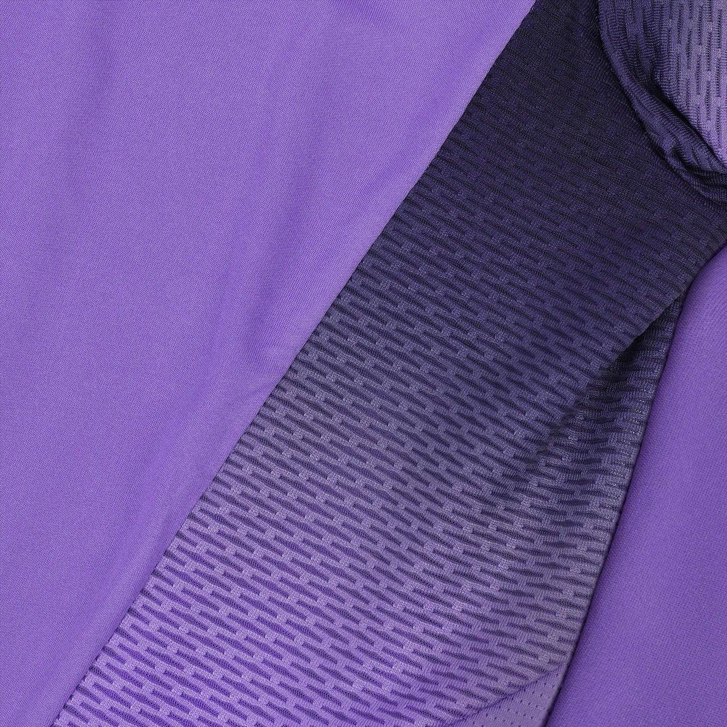 Close-up of a fabric emphasizing its fluidity, showcasing a gradient pattern that transitions from solid purple on the left to a textured black-and-purple on the right. The design is reminiscent of the Le Coq Sportif Pro Mens Padel T-Shirt in Chive Blossom, with small, repetitive lines creating a modern and dynamic appearance.