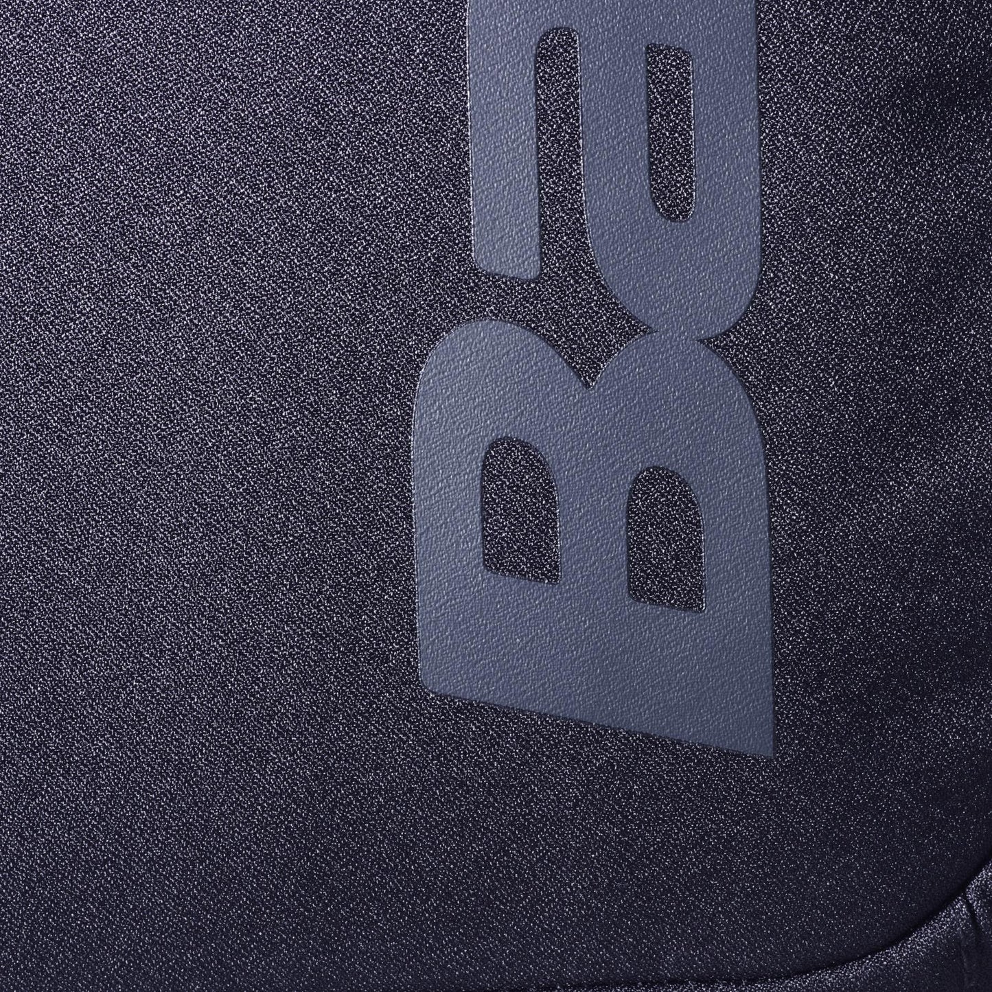 Close-up of the dark gray fabric from the Babolat Court Lite Padel Backpack - Black by Babolat, featuring a textured surface and partially visible "BA" lettering in a lighter gray shade.