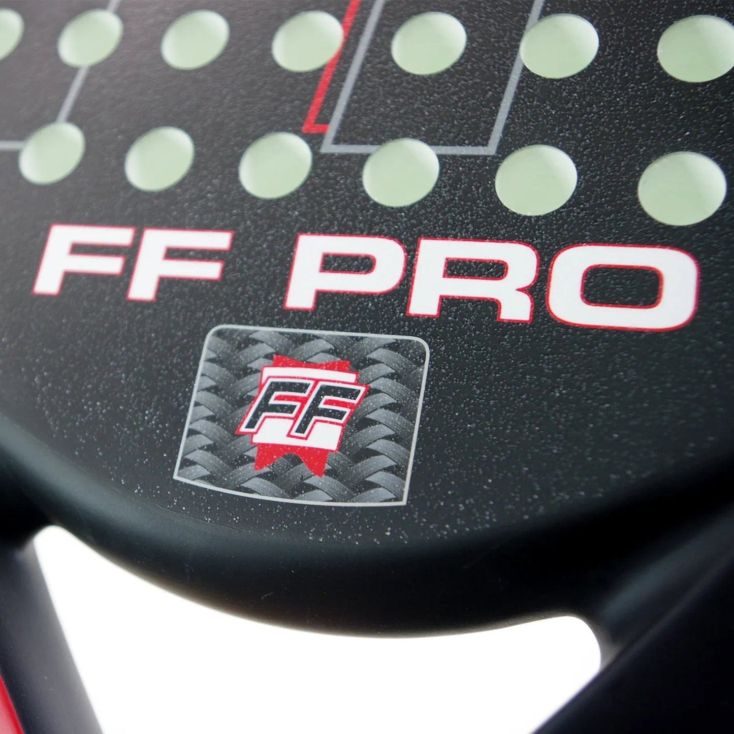 Close-up of the Karakal FF Pro 375 Padel Racket in black, showcasing white circular holes. It features "FF PRO" in red and white text and a small logo with interlocking "FF" letters on a textured carbon fiber pattern, ideal for enhancing spin shots.
