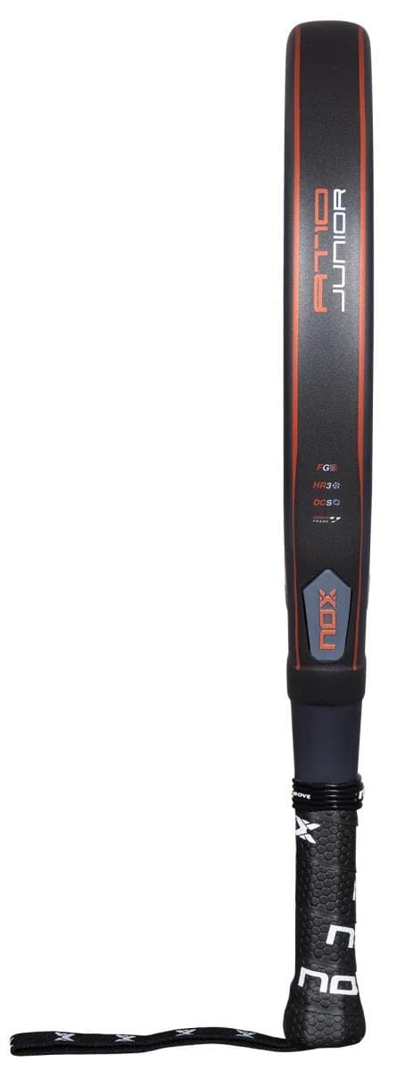The NOX AT10 Genius Junior By Augustin Tapia 2025 padel racket, in black and orange, features "AT10 Junior" on the side. Designed for young players, it draws inspiration from the AT10 Luxury Genius line and includes a visible wrist strap.