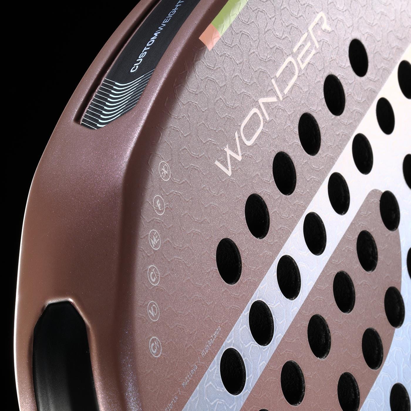 Close-up of the Bullpadel Wonder 2026 Padel Racket in rose gold, featuring a textured surface, Hyper Core technology, black circular holes, "WONDER" branding, edge logo, and a custom weight system for pro-level play.
