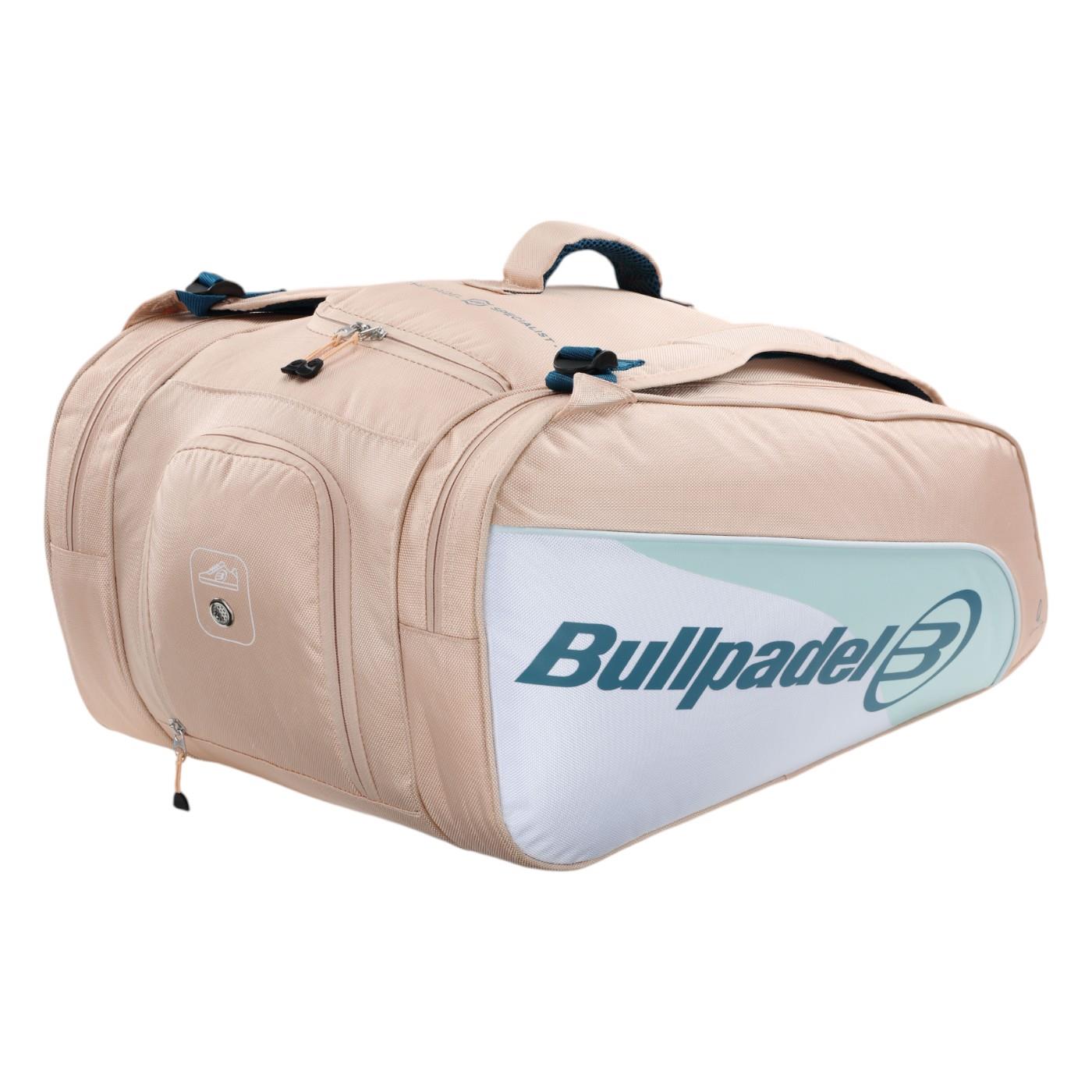 The Bullpadel Elite 25 Padel Racket Bag in pink, inspired by player Gemma Triay, has multiple compartments, including thermo-lined ones with zippers. It features "Bullpadel" branding and a logo on the side, plus two handle straps on top for easy carrying.