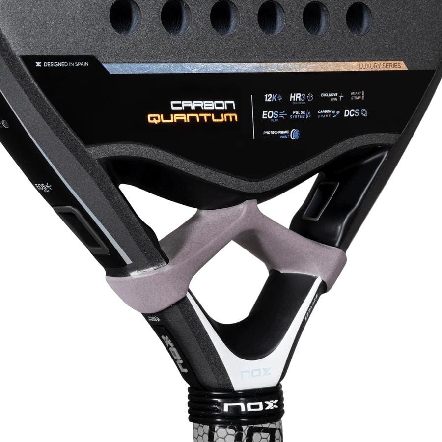 Close-up of the NOX Luxury Quantum 12K Carbon 2025 Padel Racket handle and throat in black/grey, showcasing Quantum CARBON 12k branding, HR3 Colour Eva, EXCLUSIVE SPIN tech, specs, and frame design details.