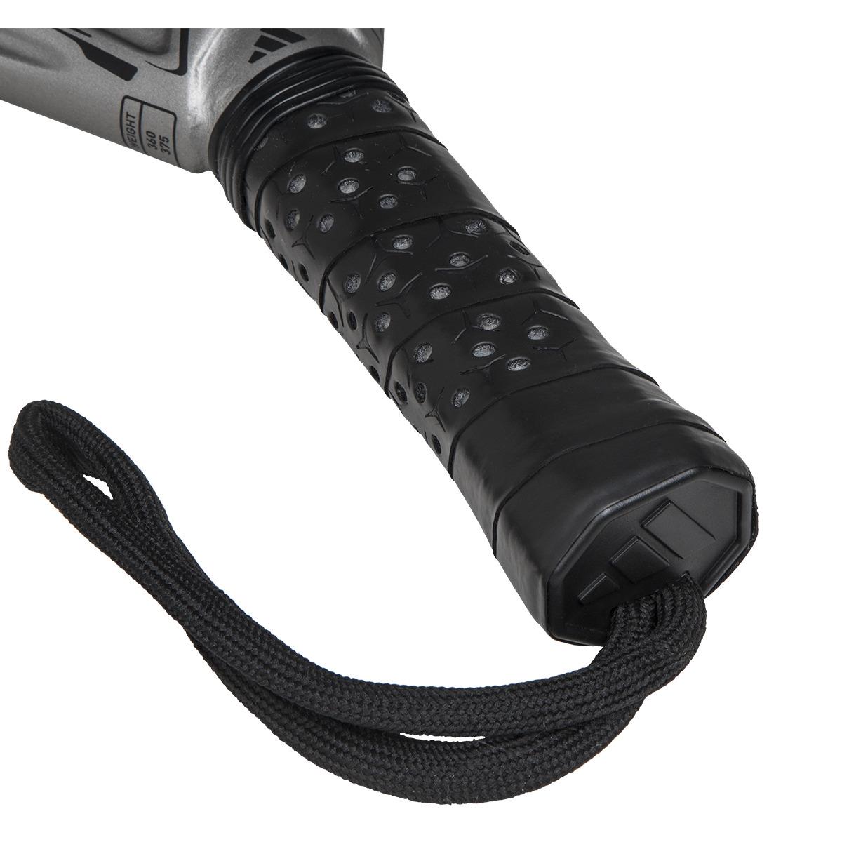 A close-up of a black textured rubber handle grip with a ridged pattern is attached to a black cord loop, evoking the adidas Adipower Carbon Light 3.4 Padel Racket design, featuring Carbon 3K Fibre and a metallic silver section visible at the upper edge.