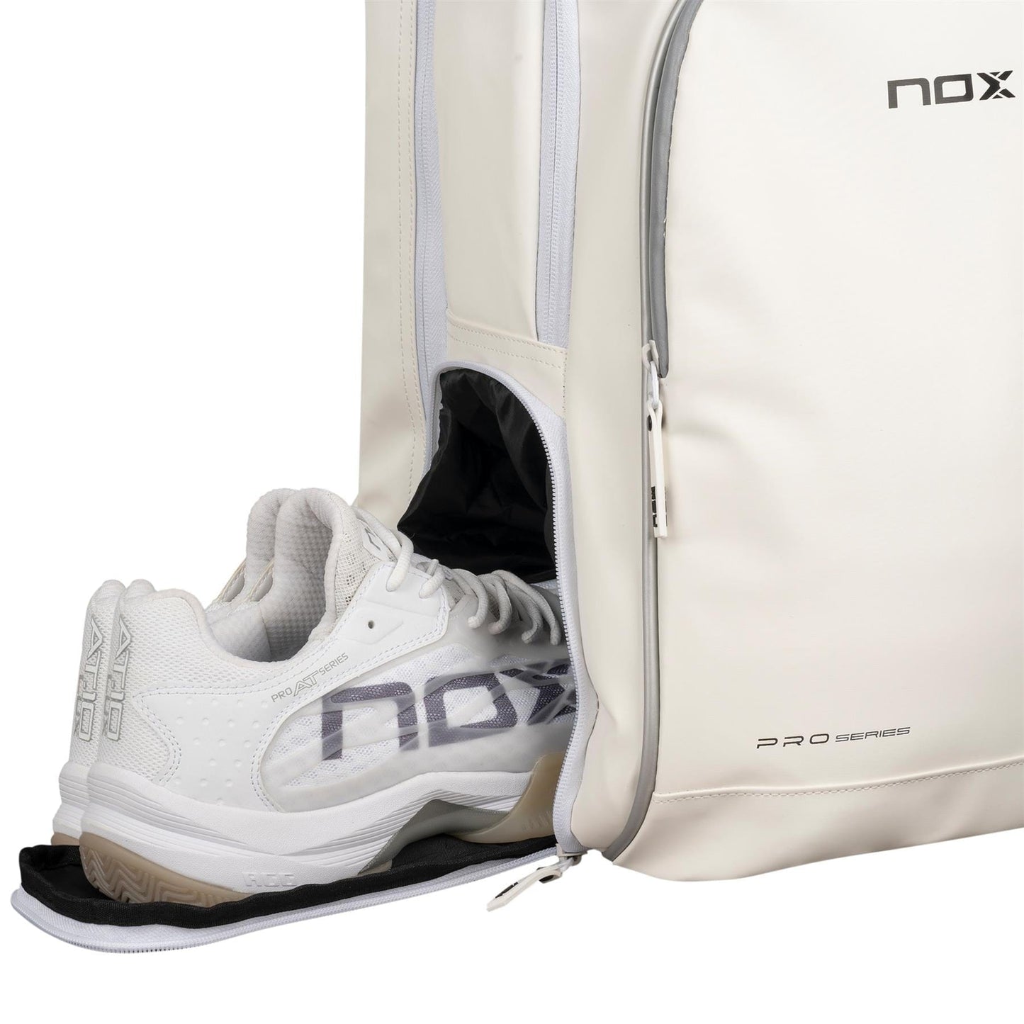 A pair of white NOX athletic shoes is partially tucked into a white NOX Pro Series Padel Backpack with a side zipper compartment; both feature "nox" branding.