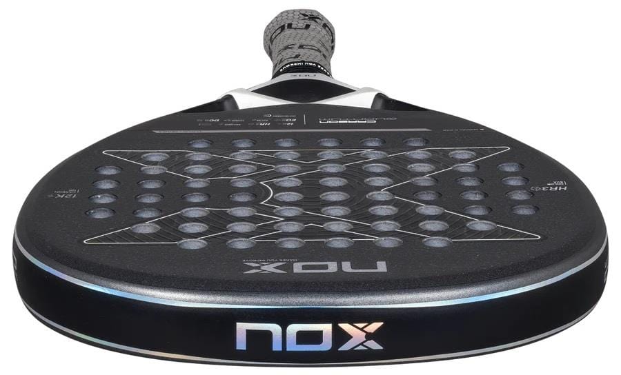 A close-up shows the NOX Luxury Quantum 12K Carbon 2025 Padel Racket in black/grey, highlighting its round, perforated head and textured surface with EXCLUSIVE SPIN technology. The NOX brand is visible on the lower edge.