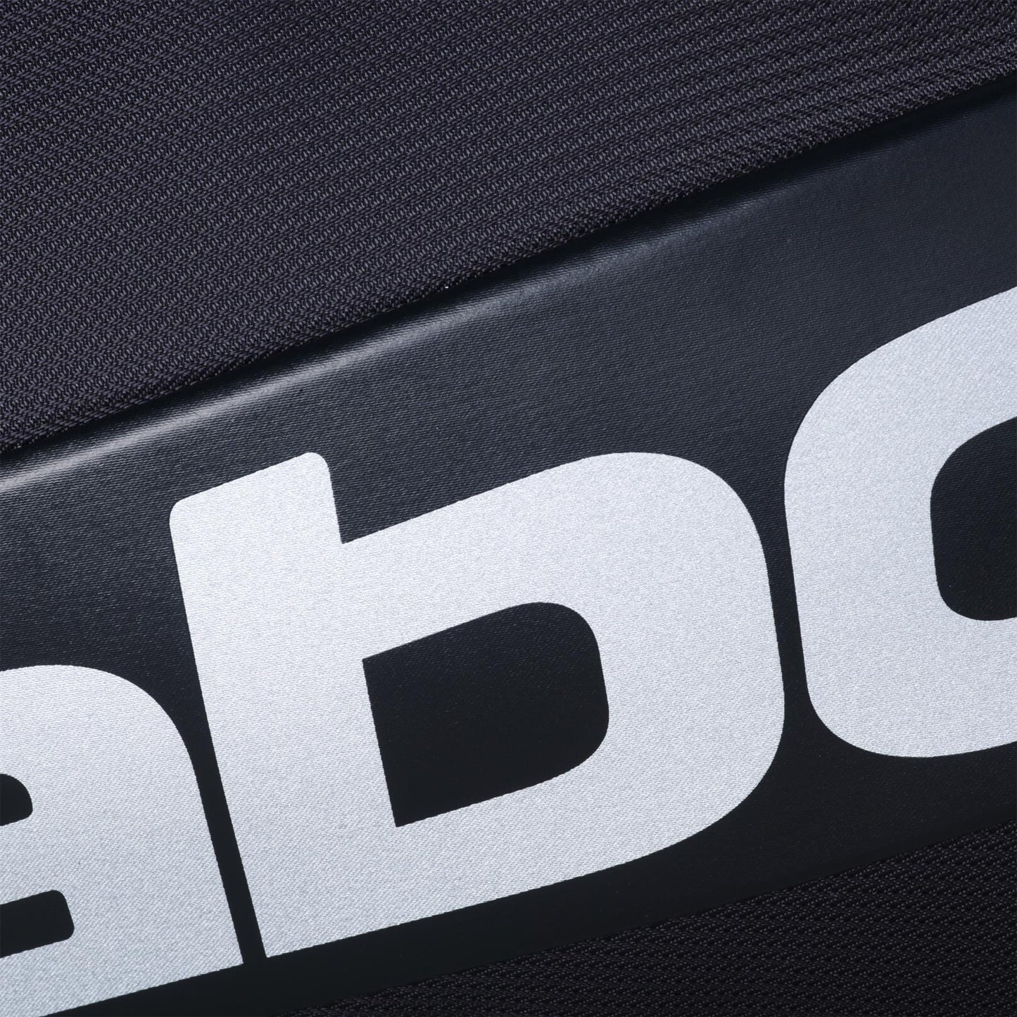 Close-up of the black surface of the Babolat RH Pro 4 Racket Padel Bag by Babolat, showing bold white letters from the logo against a textured background.