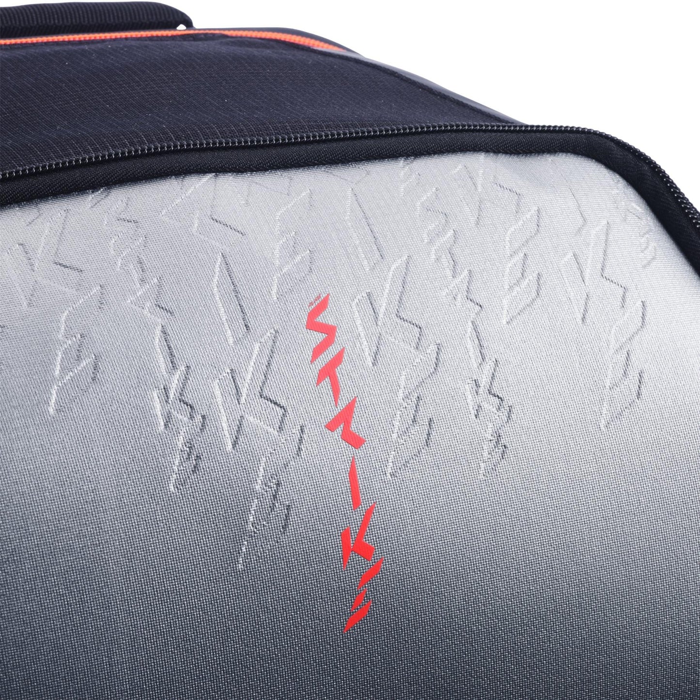 Close-up of the textured gray and black surface on the Babolat Pure Strike Tennis Backpack - Carbon Grey by Babolat, featuring embossed zigzag patterns and a bold vertical line of red zigzag shapes in the center.