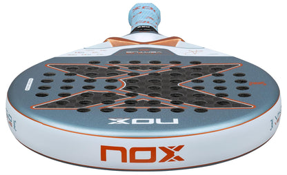 A close-up of the NOX Luxury VK10 Ventus Control 12K By Aranzazu Osoro 2026 Padel Racket shows its black X design, circular holes, blue-orange-white accents, and NOX logo. Made with 12K carbon for top performance.