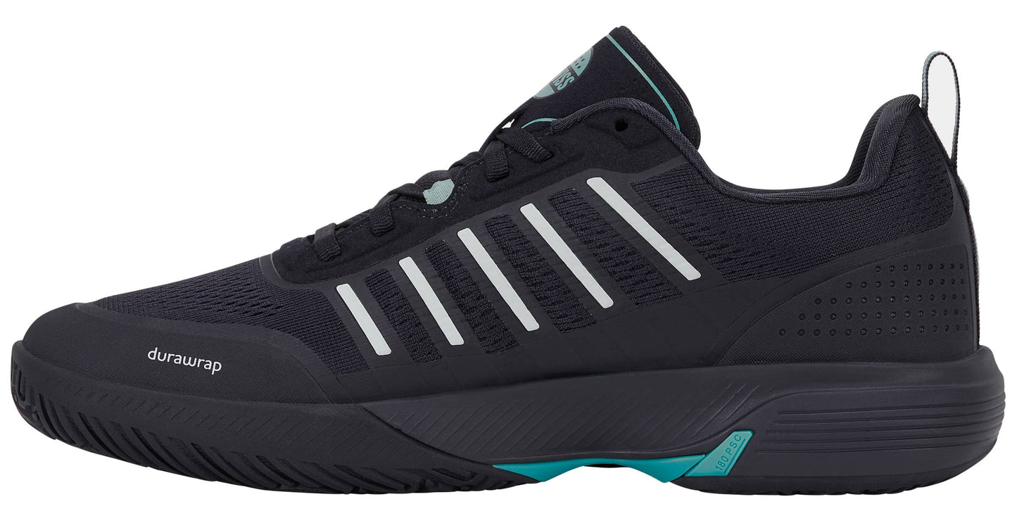 Black athletic sneaker with white stripes, teal accents, and “durawrap” text on the side. The K-Swiss Ultra Court Men’s Padel Shoes in Carbon / Baltic / Glacier Gray offer a lightweight design inspired by high-performance padel footwear, featuring a low-profile silhouette, textured sole for optimal traction on court surfaces, and a convenient heel pull tab.