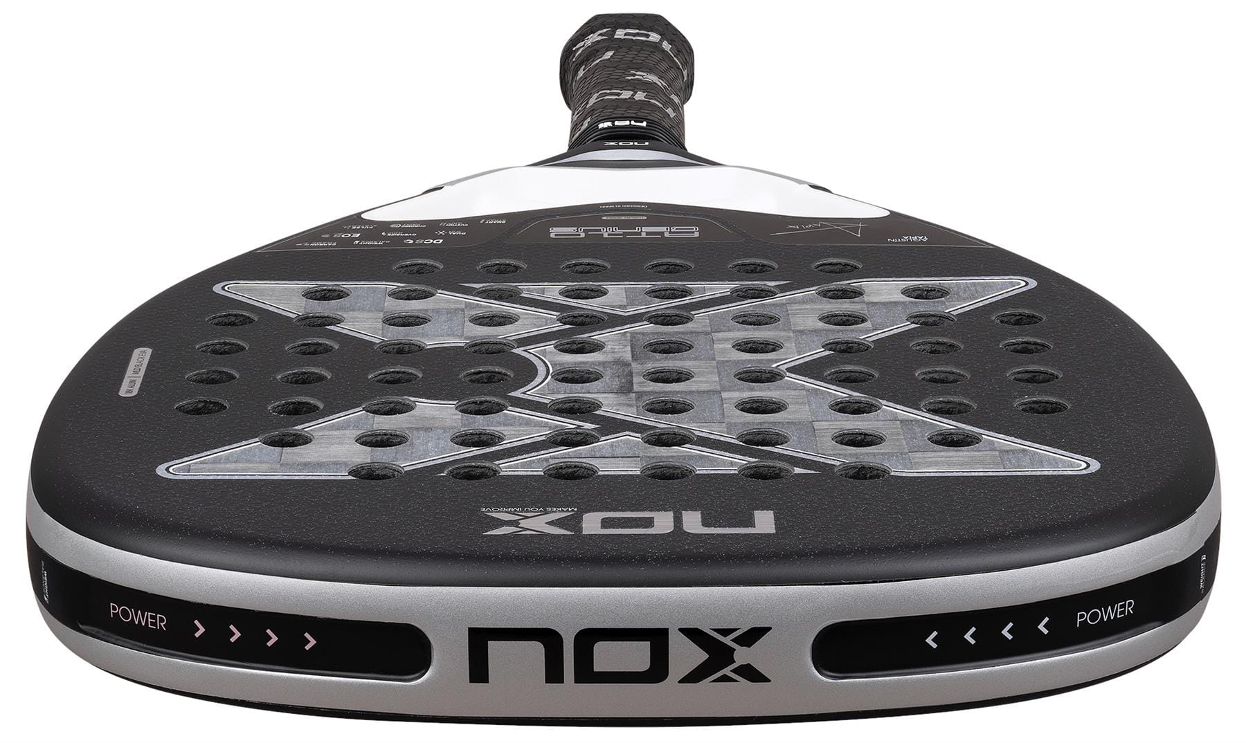 Close-up of the NOX Luxury AT10 Genius Attack 18K Alum By Agustin Tapia 2026 Padel Racket, featuring a black and silver face with a large "X" design, circular perforations, and an 18K aluminised carbon finish.