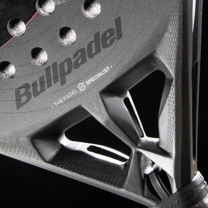 Close-up of the Bullpadel HACK 04 Hybrid 2026 Padel Racket in grey/black, featuring the Bullpadel logo and structural holes, highlights its dynamic power, detailed texture, and design on a dark background.