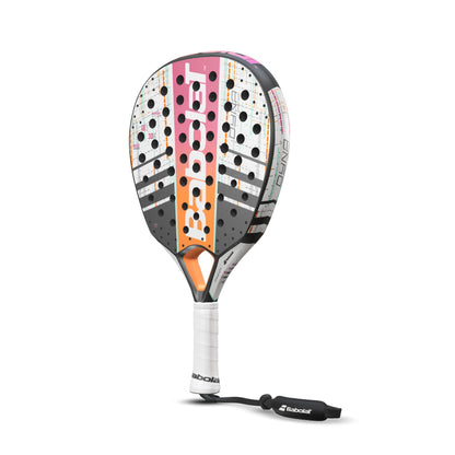 The Babolat Dyna Energy Padel Racket in White and Pink boasts a vibrant design with pink, orange, and black accents. It features a perforated face, a white grip, and a safety strap. Enhanced with Carbon Flex technology for improved performance, the brand name Babolat is prominently showcased on the racket.