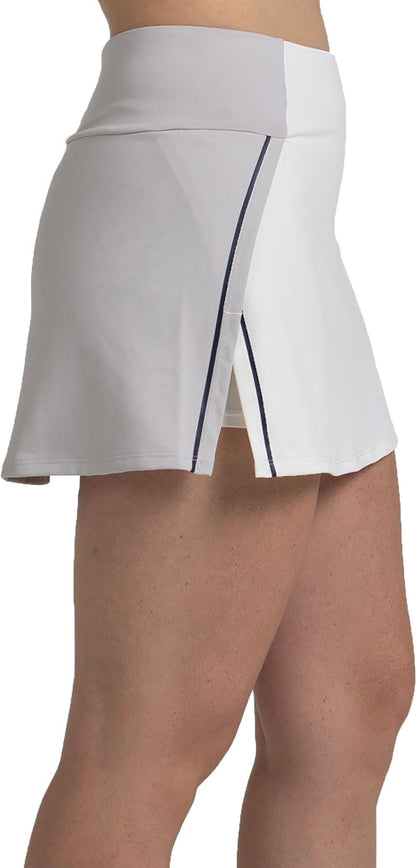 A close-up side view shows a person wearing the Bullpadel Pugue Women's Padel Skirt in Bone—a high-waisted, white performance skirt with a front slit and thin dark stripe, revealing their waist and upper legs.