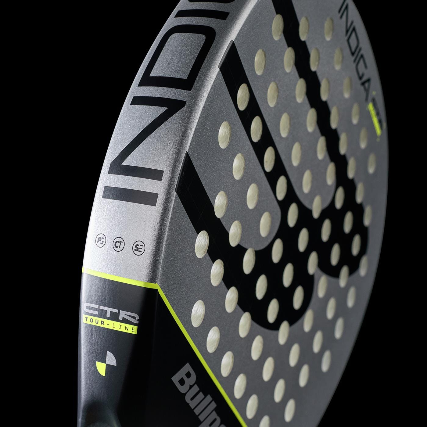 Close-up of the Bullpadel Indiga Ctr 2026 padel racket in grey, black, and neon yellow, featuring "Bullpadel" and "INDIGA" on the frame, highlighting its precision control against a sleek black background.